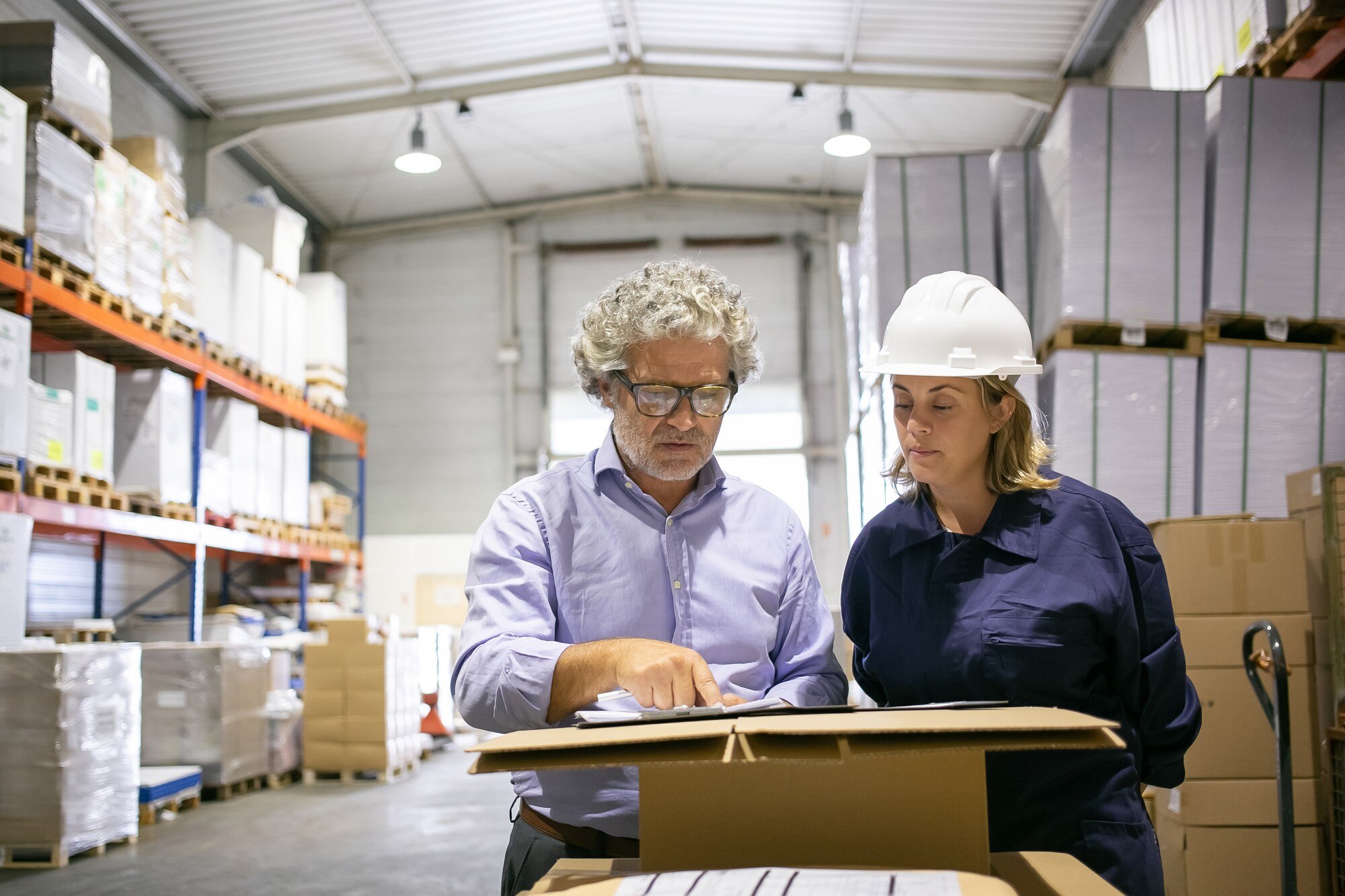 safety-inspector-consulting-female-logistic-worker-while-completing-form-warehouse-copy-space-front-view-labor-inspection-concept_74855-14261