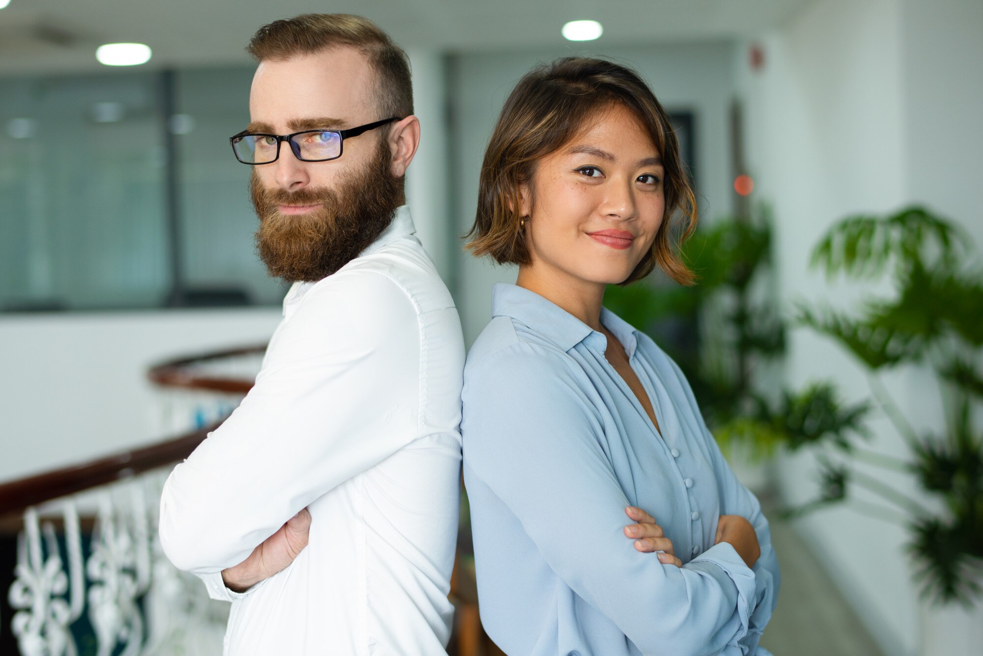 content-young-multi-ethnic-colleagues-standing-back-back_1262-17849