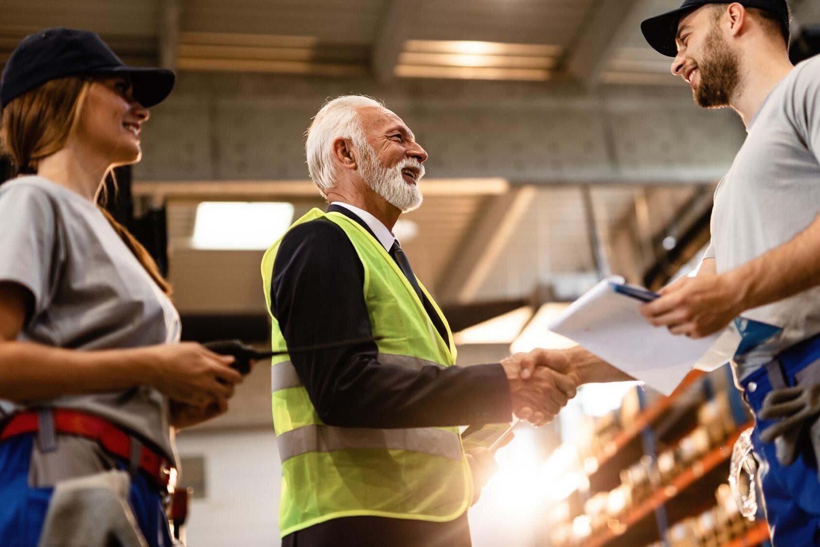 inquadratura-dal-basso-di-un-felice-senior-manager-che-saluta-i-suoi-dipendenti-in-un-magazzino-di-fabbrica-mi-sto-stringendo-la-mano_637285-4192