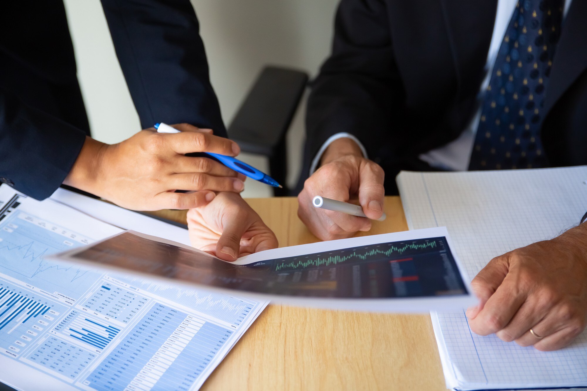 investor-broker-discussing-trading-strategy-holding-papers-with-financial-charts-pens-cropped-shot-broker-job-investment-concept_74855-14251